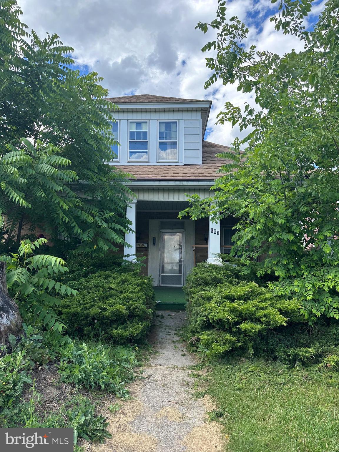 a front view of a house with plants and garden