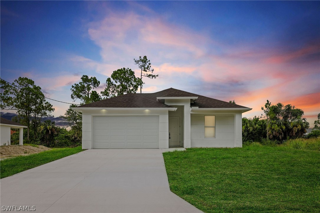 a front view of a house with a yard and garage