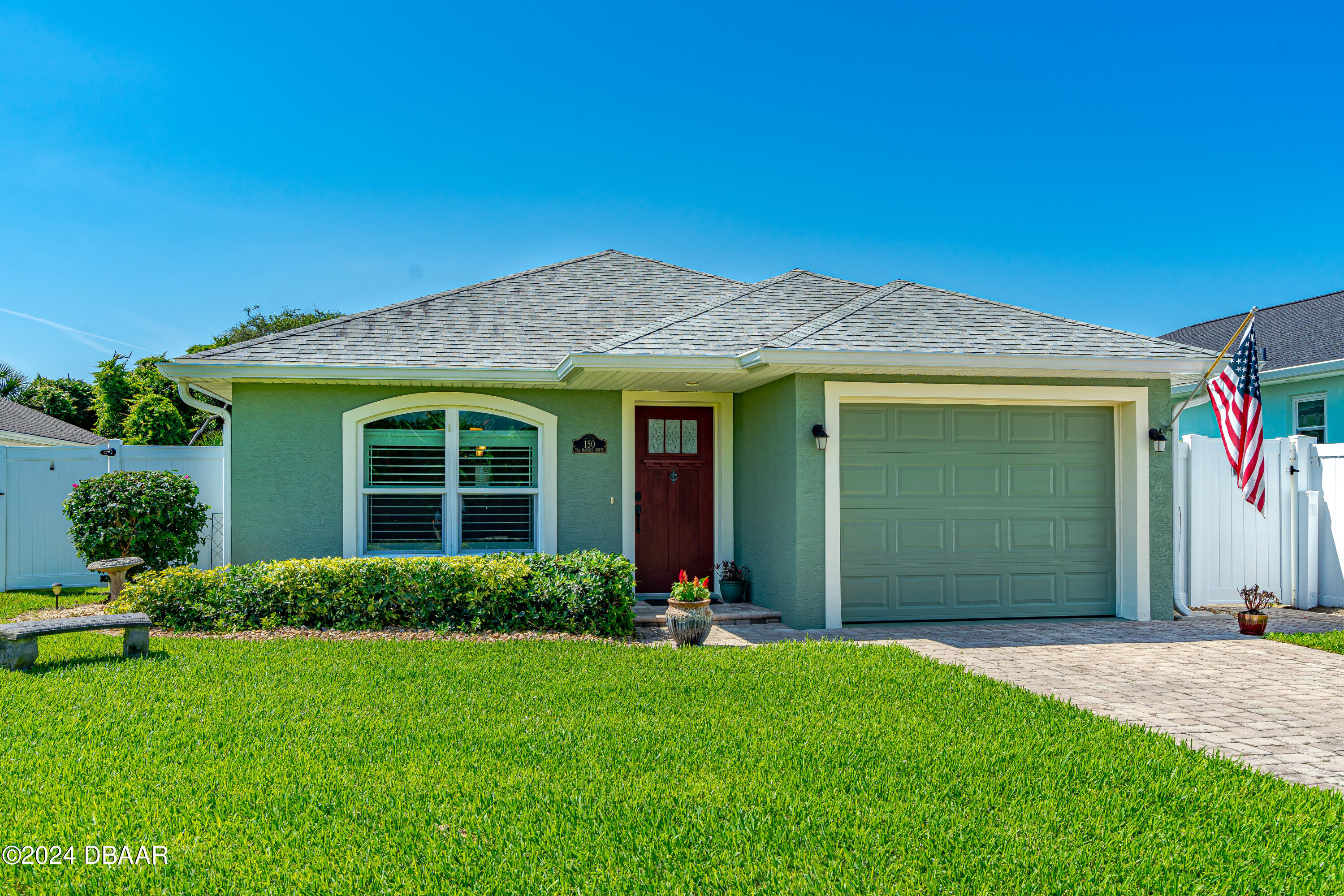 a front view of a house with a garden and yard