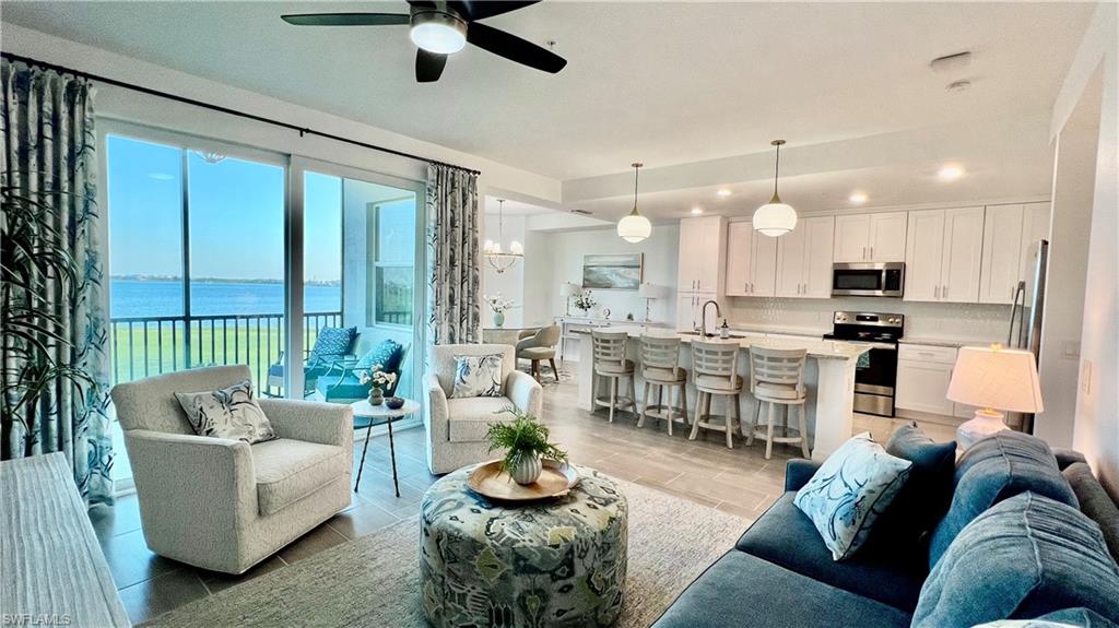 a living room with furniture kitchen and a large window