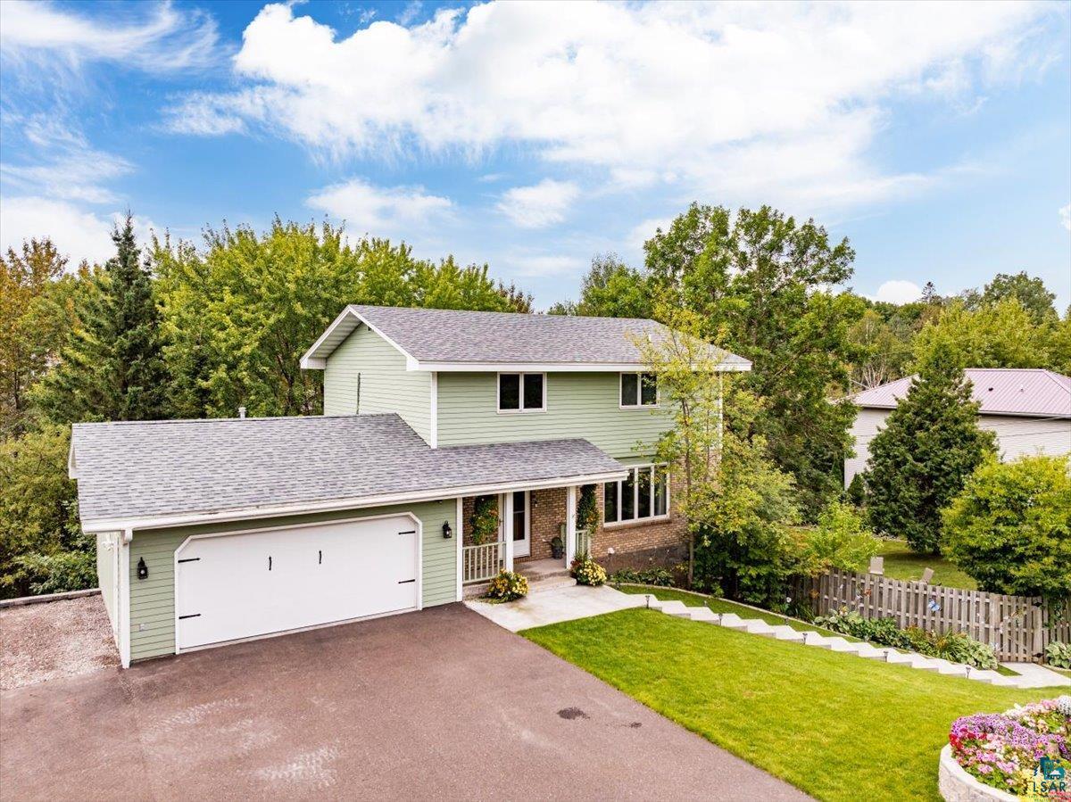 View of front of house with a garage and a front yard