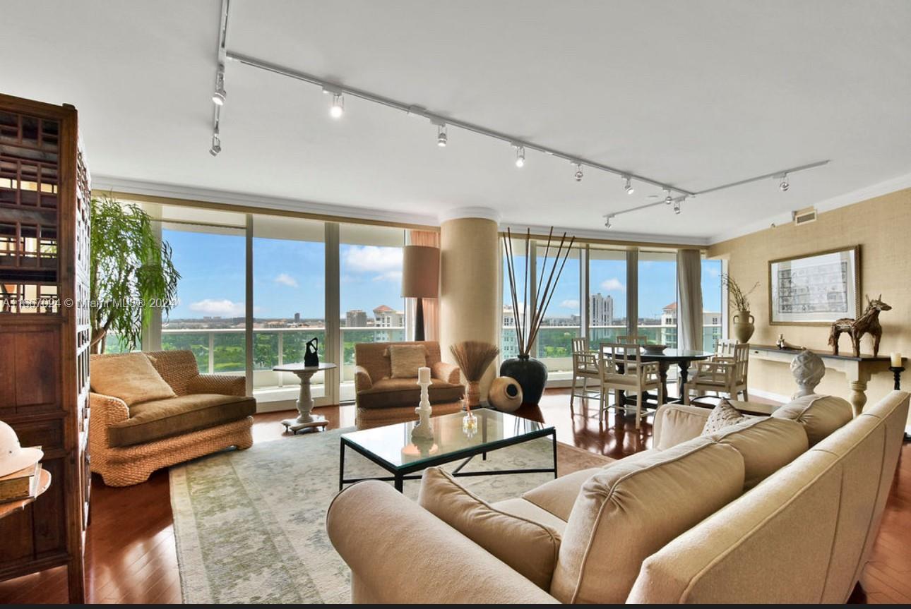 a living room with furniture and floor to ceiling windows