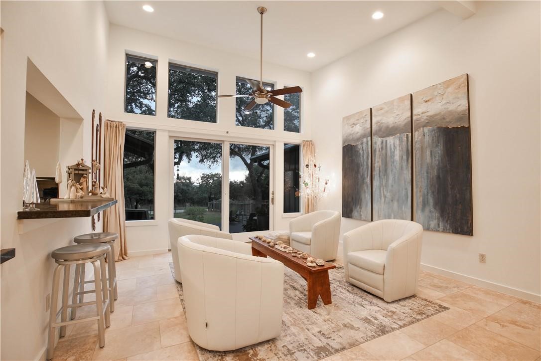 a living room with furniture a large window and chandelier