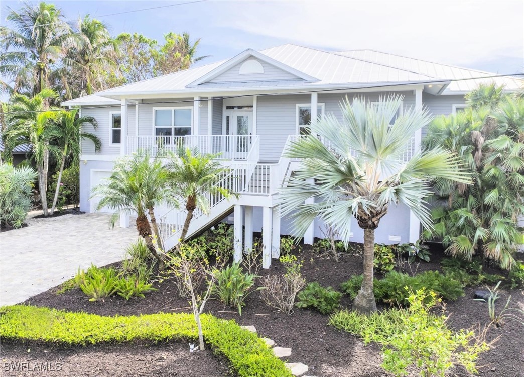 a front view of a house with a yard and potted plants