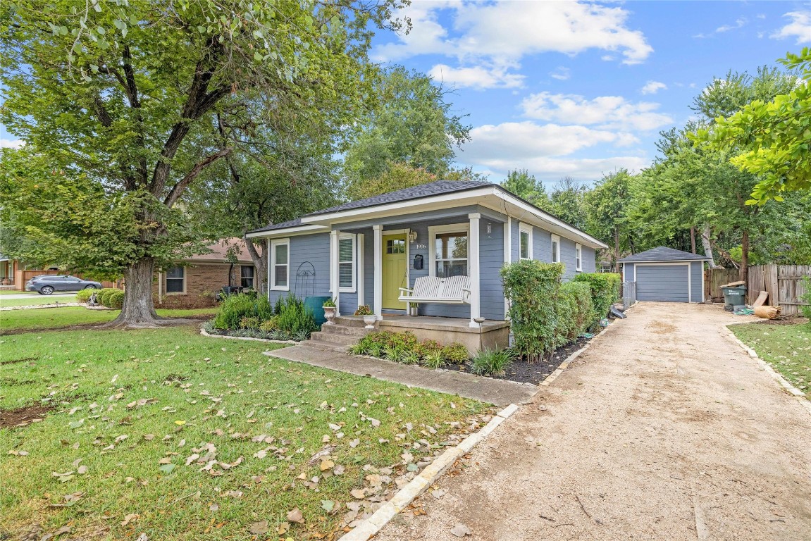 a view of house with a big yard plants and large trees