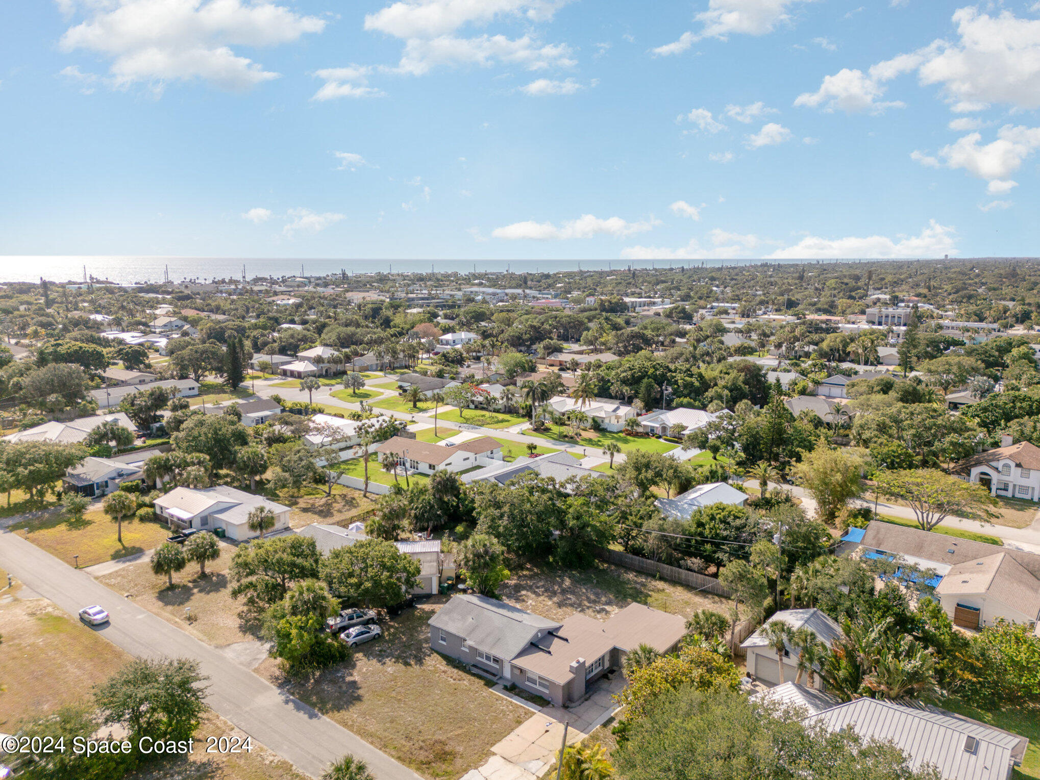 an aerial view of residential houses with outdoor space and trees