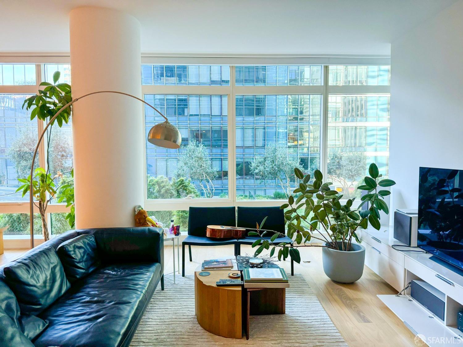 a living room with furniture potted plant and a large window