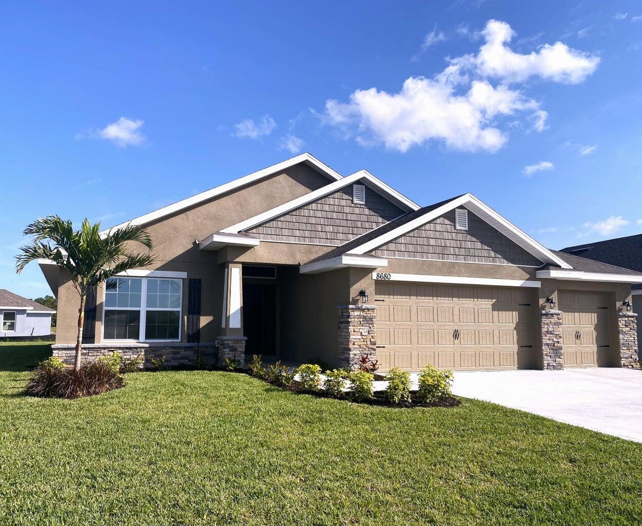 a front view of a house with a garden and yard