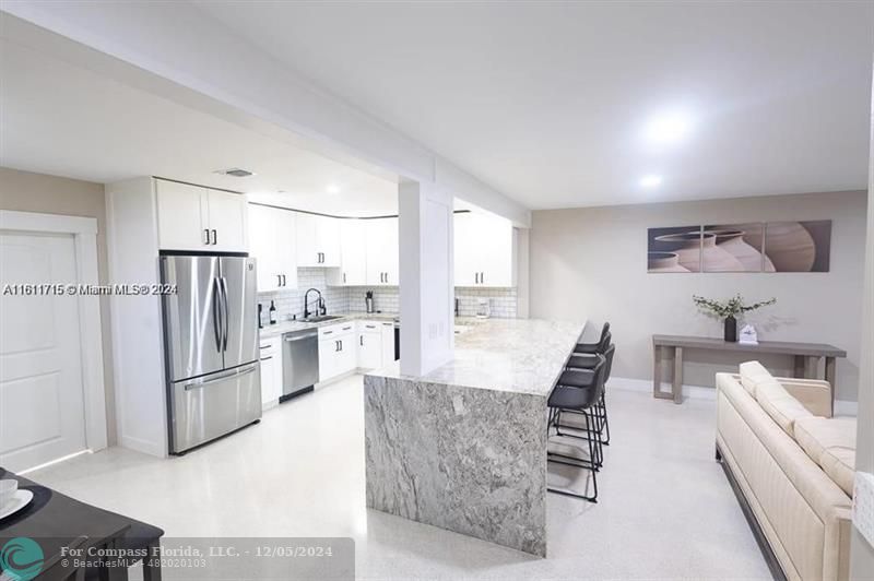 a large kitchen with a large window and stainless steel appliances