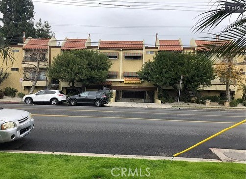 a view of a building and car parked on the road