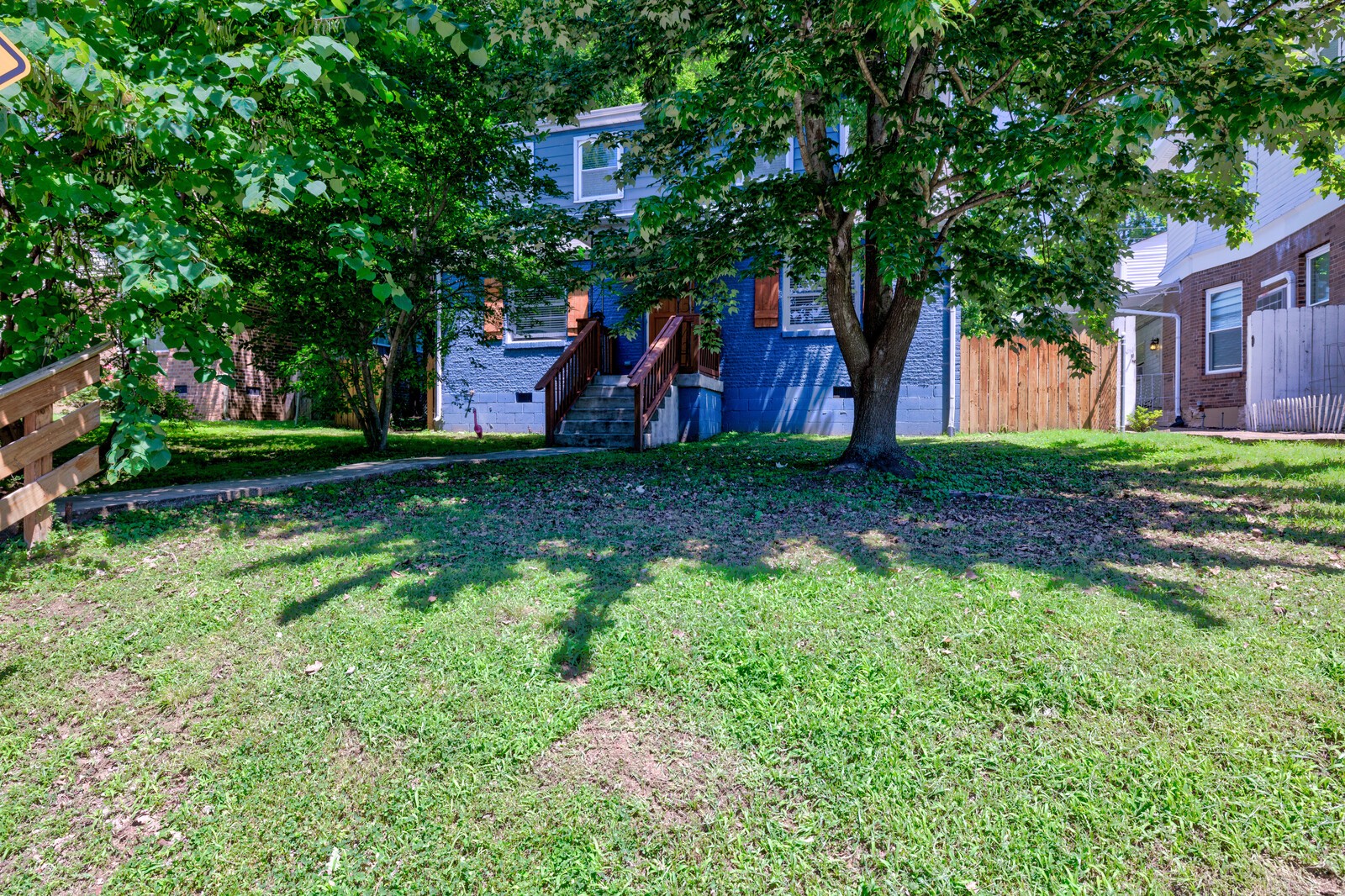 a backyard of a house with lots of green space and fountain