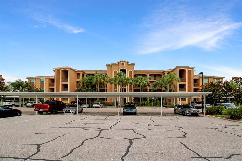 a view of building with lot of cars parked in front of it