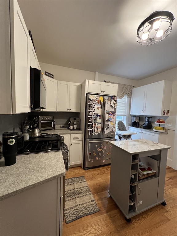 a kitchen with granite countertop a sink a counter top space and cabinets