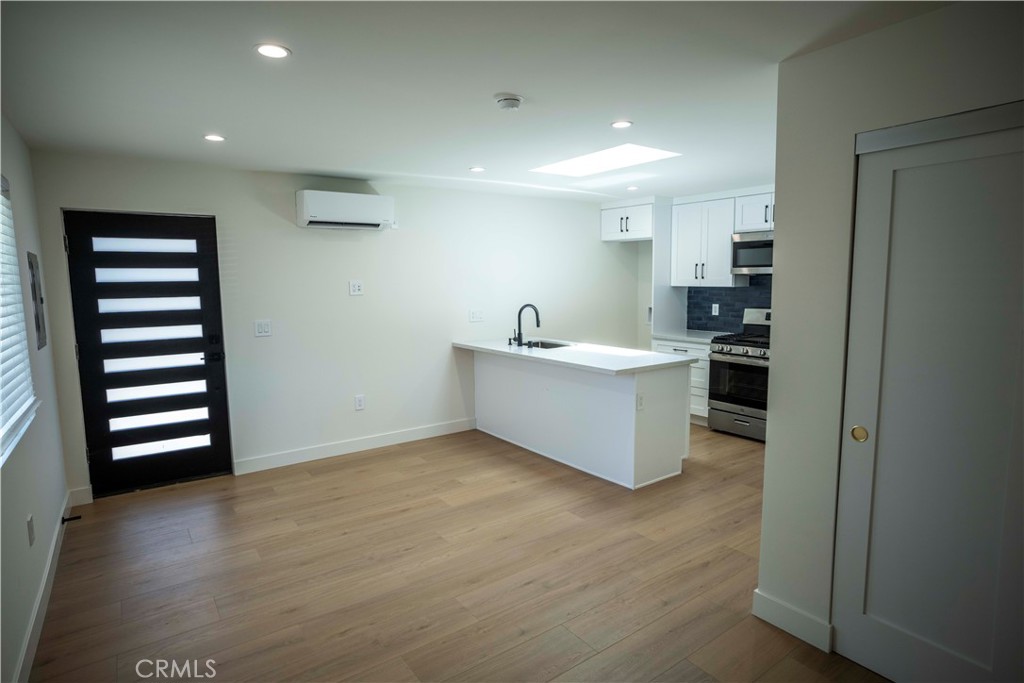 a view of kitchen with stainless steel appliances cabinets and wooden floor