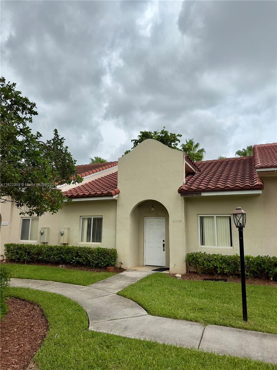 a front view of a house with a garden and yard