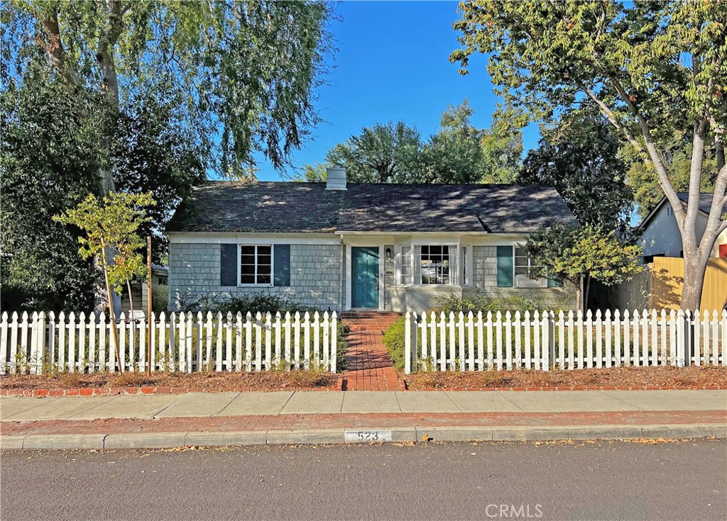 a view of a house with a small yard and wooden fence