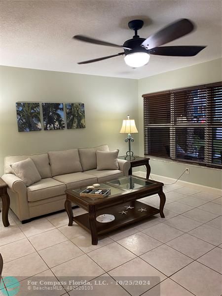 a living room with furniture and ceiling fan