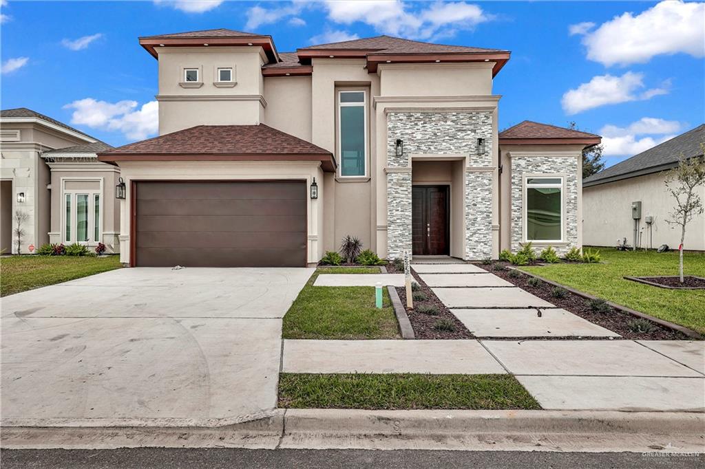 a front view of a house with a yard and garage