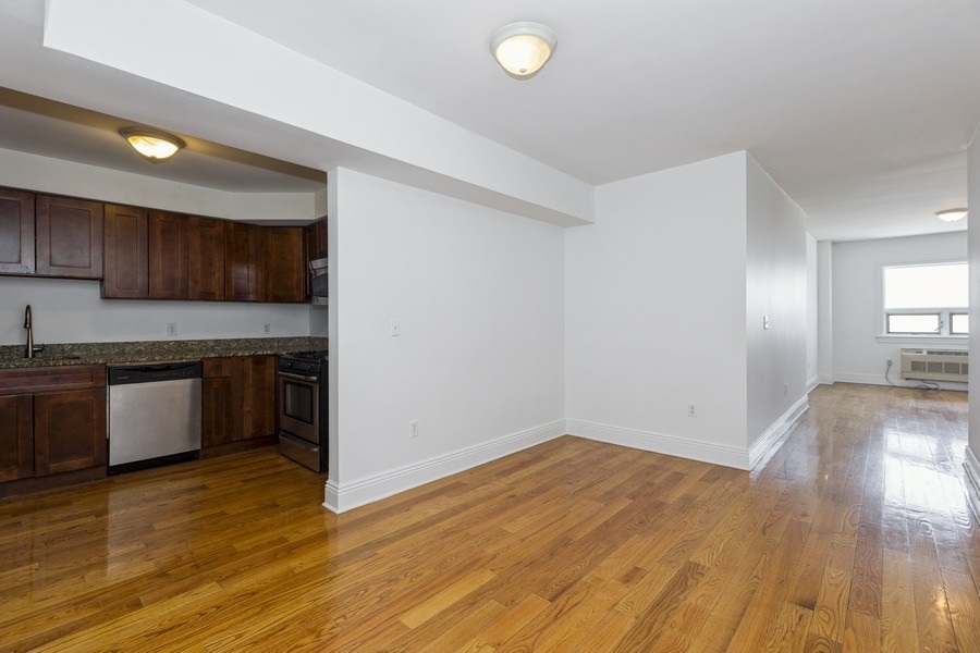 a kitchen with granite countertop a stove and a wooden floors