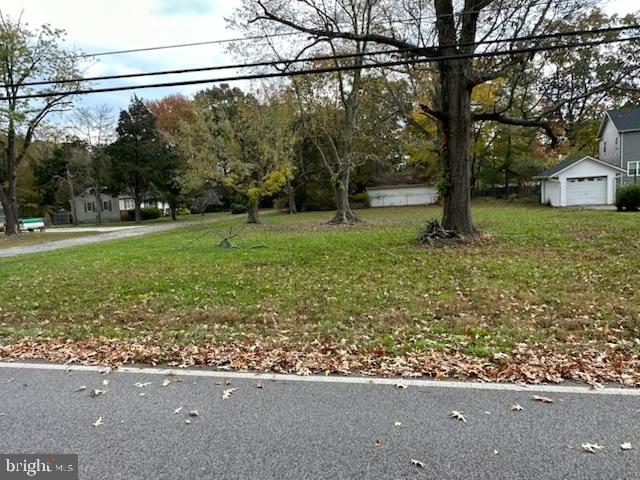 a view of a yard with a street sign and a tree