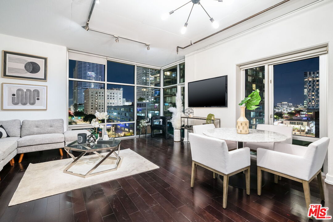 a living room with furniture a flat screen tv and wooden floor