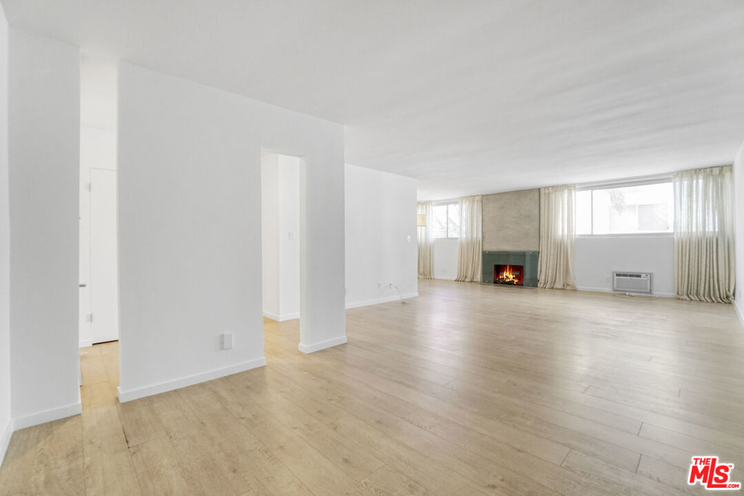 a view of empty room with a fireplace and wooden floor