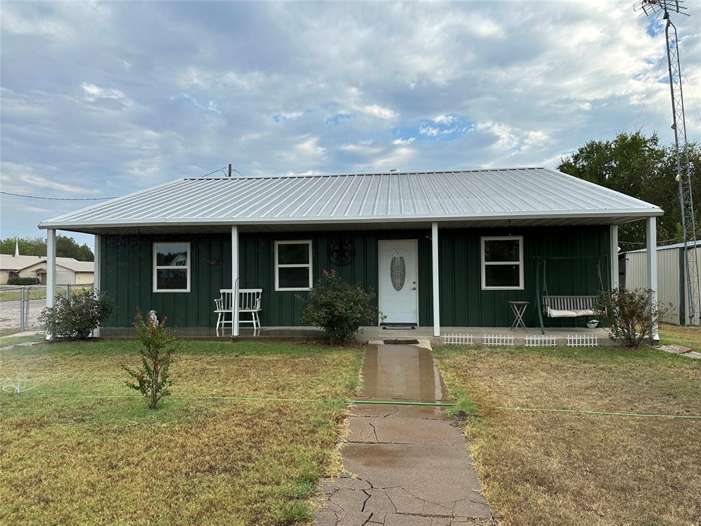 a front view of a house with a yard and outdoor seating