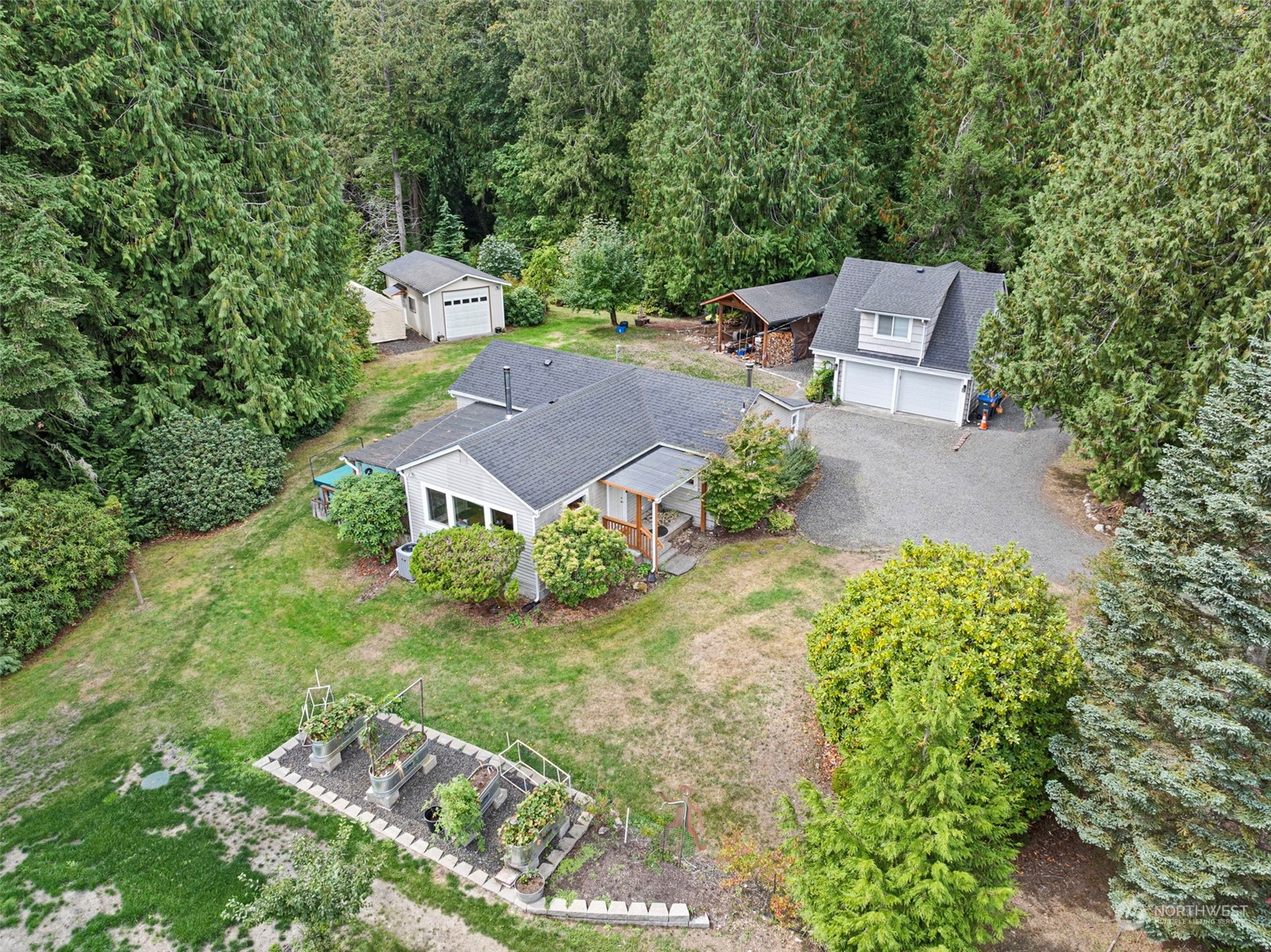 an aerial view of a house with garden space and a bench