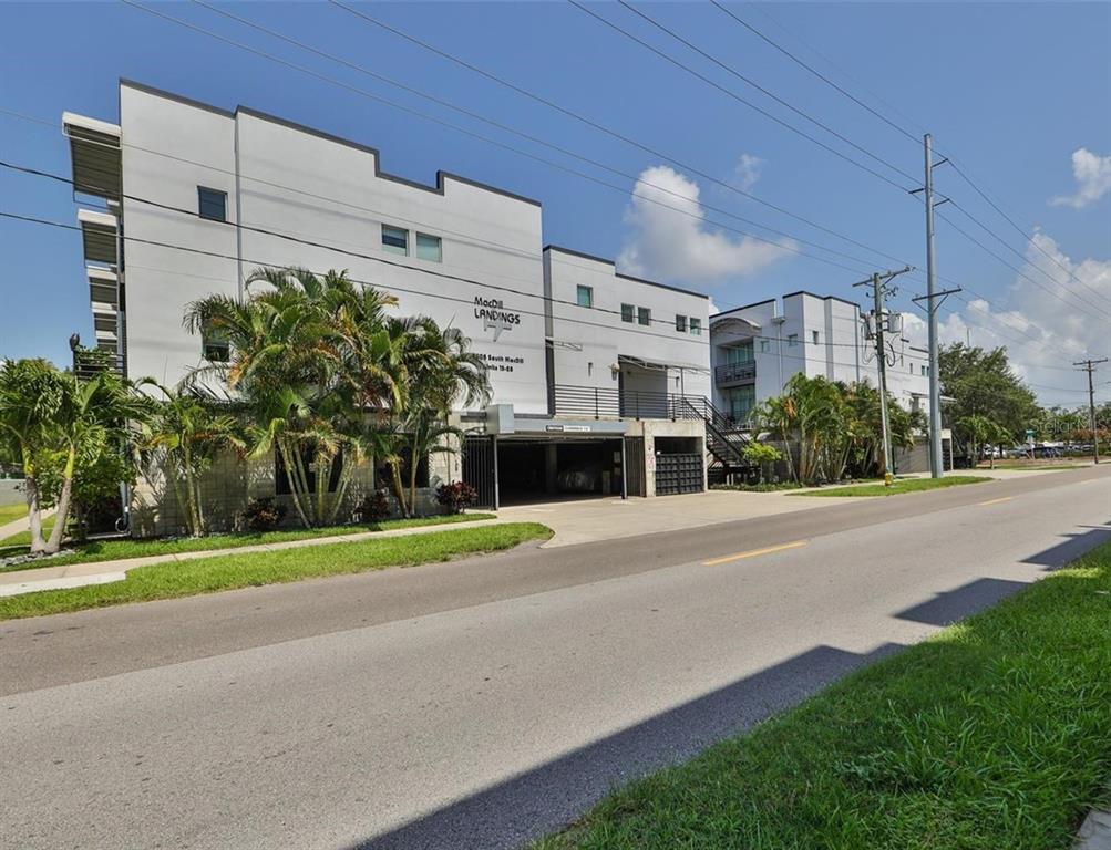 a front view of a building with a yard and trees