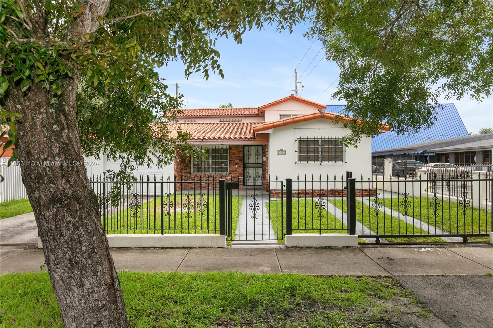 a front view of a house with a garden and plants