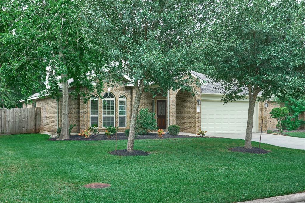 a front view of a house with a yard and tree