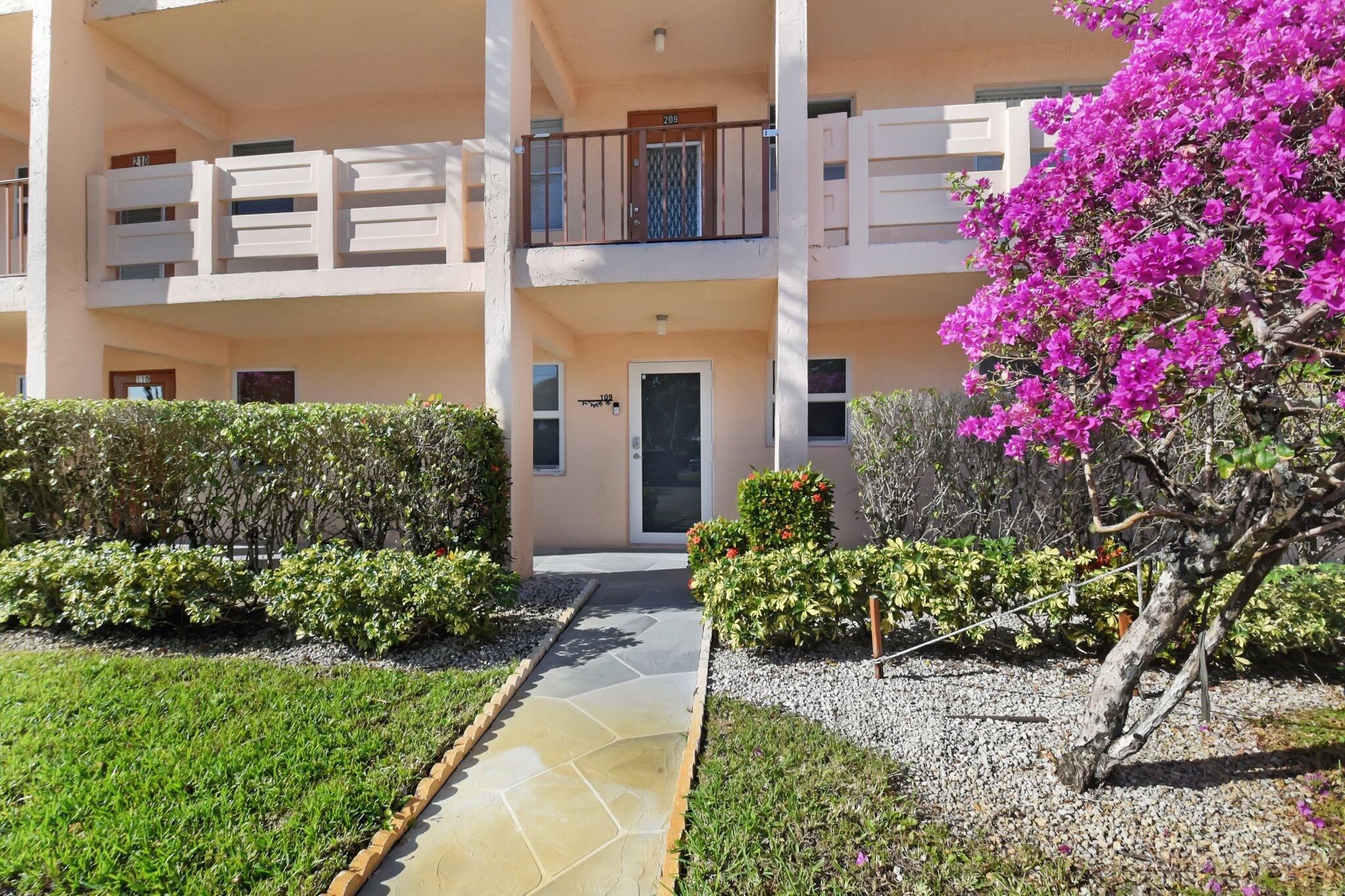 a front view of a multi story residential apartment building with a yard