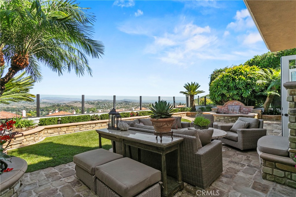 a view of a patio with couches potted plants and a big yard