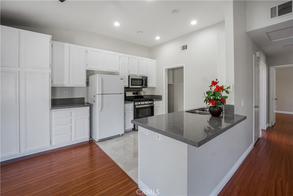 a kitchen with stainless steel appliances granite countertop a refrigerator and a sink