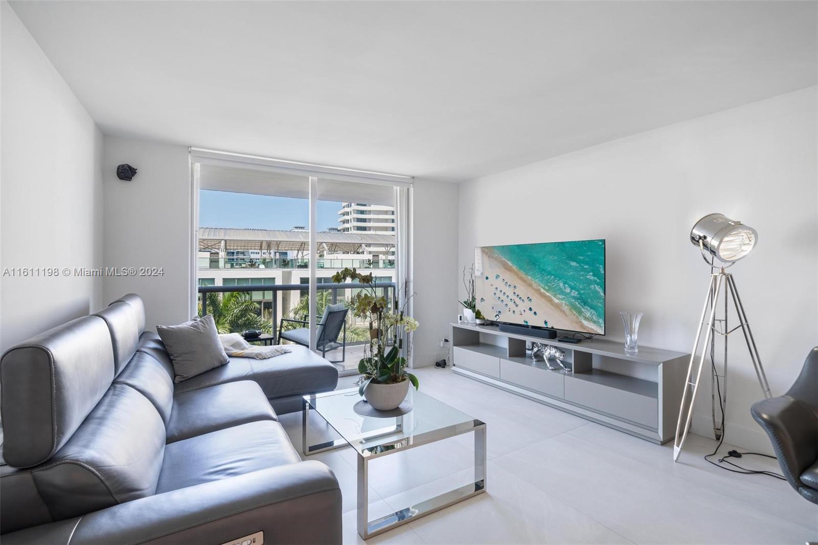 a living room with furniture a flat screen tv and a large window