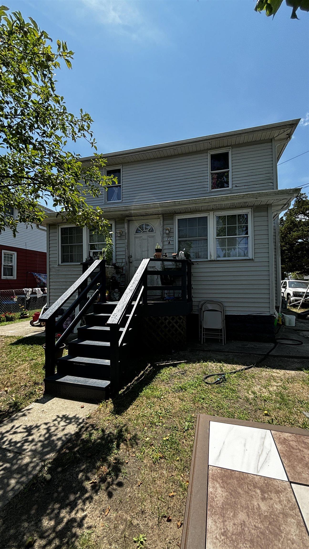 a view of a house with backyard and sitting area