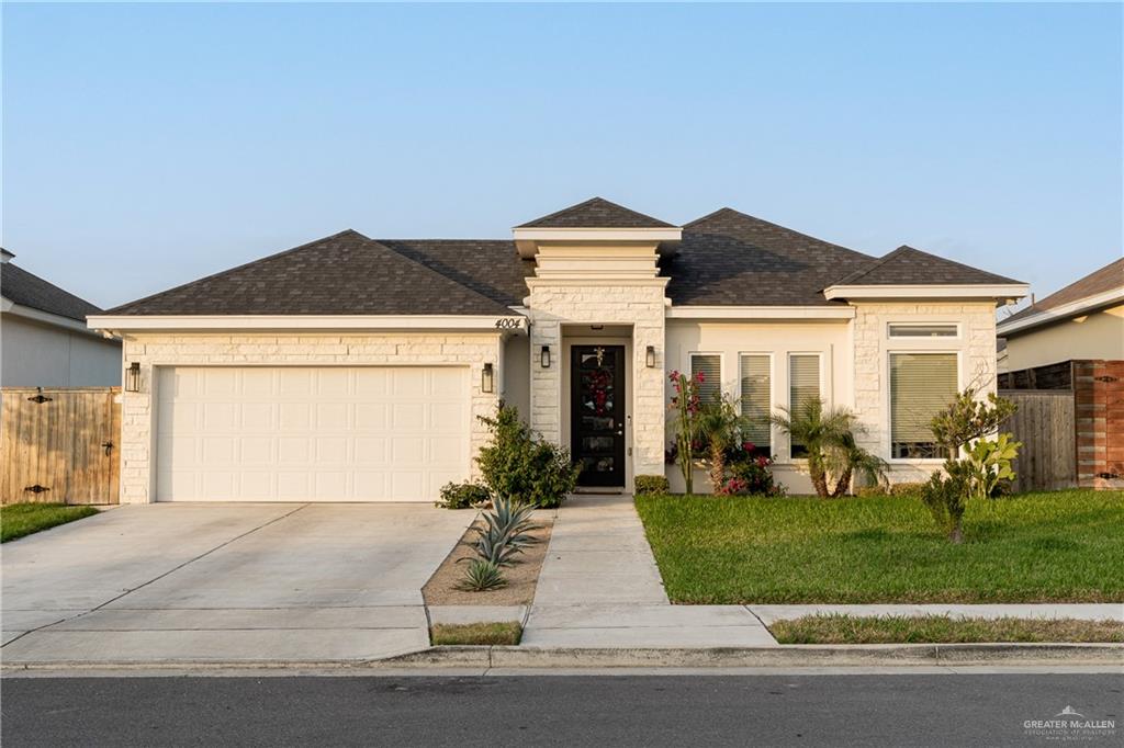 View of front of property with a front yard and a garage