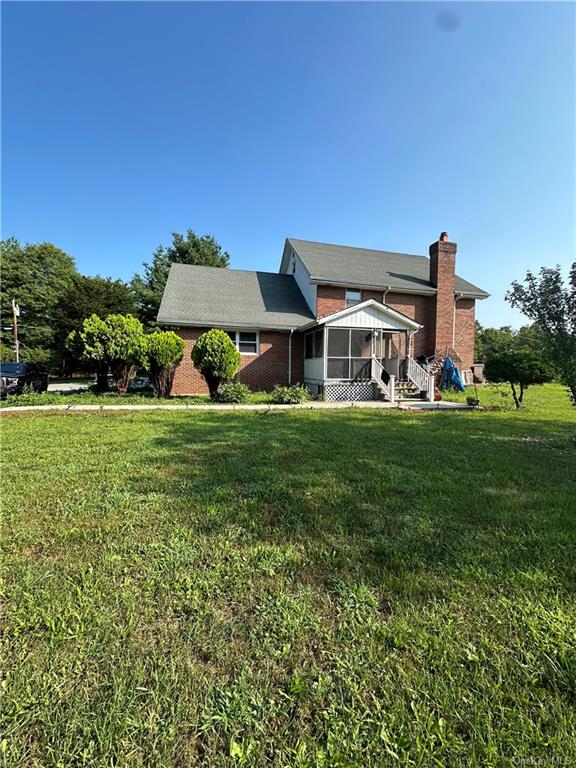 a view of a house with a yard and sitting area