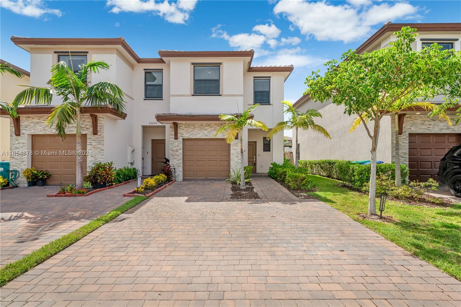 a front view of a house with a yard and a garage