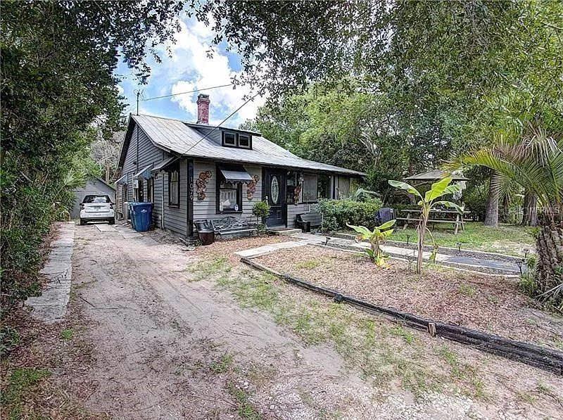 a view of a house with backyard and a tree