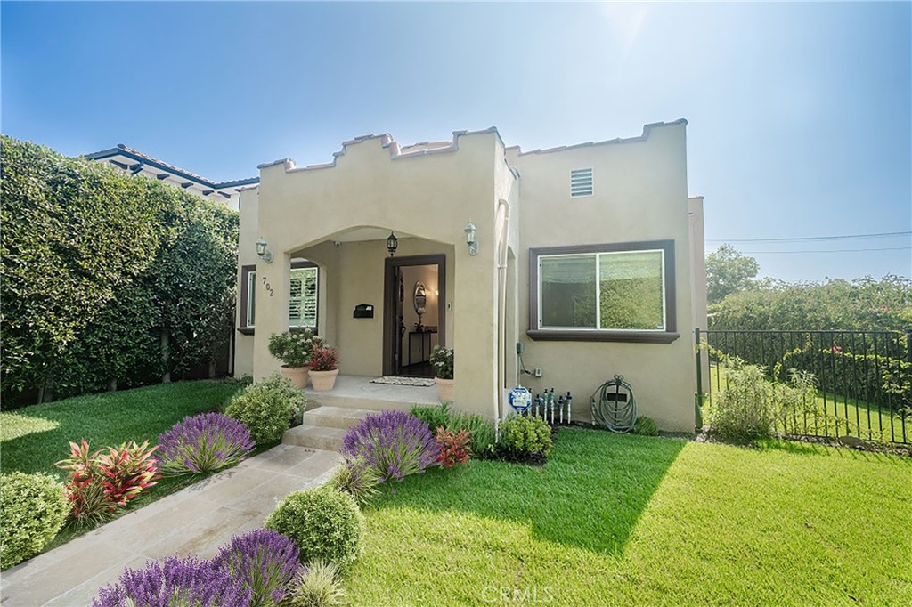 a front view of a house with a garden and plants