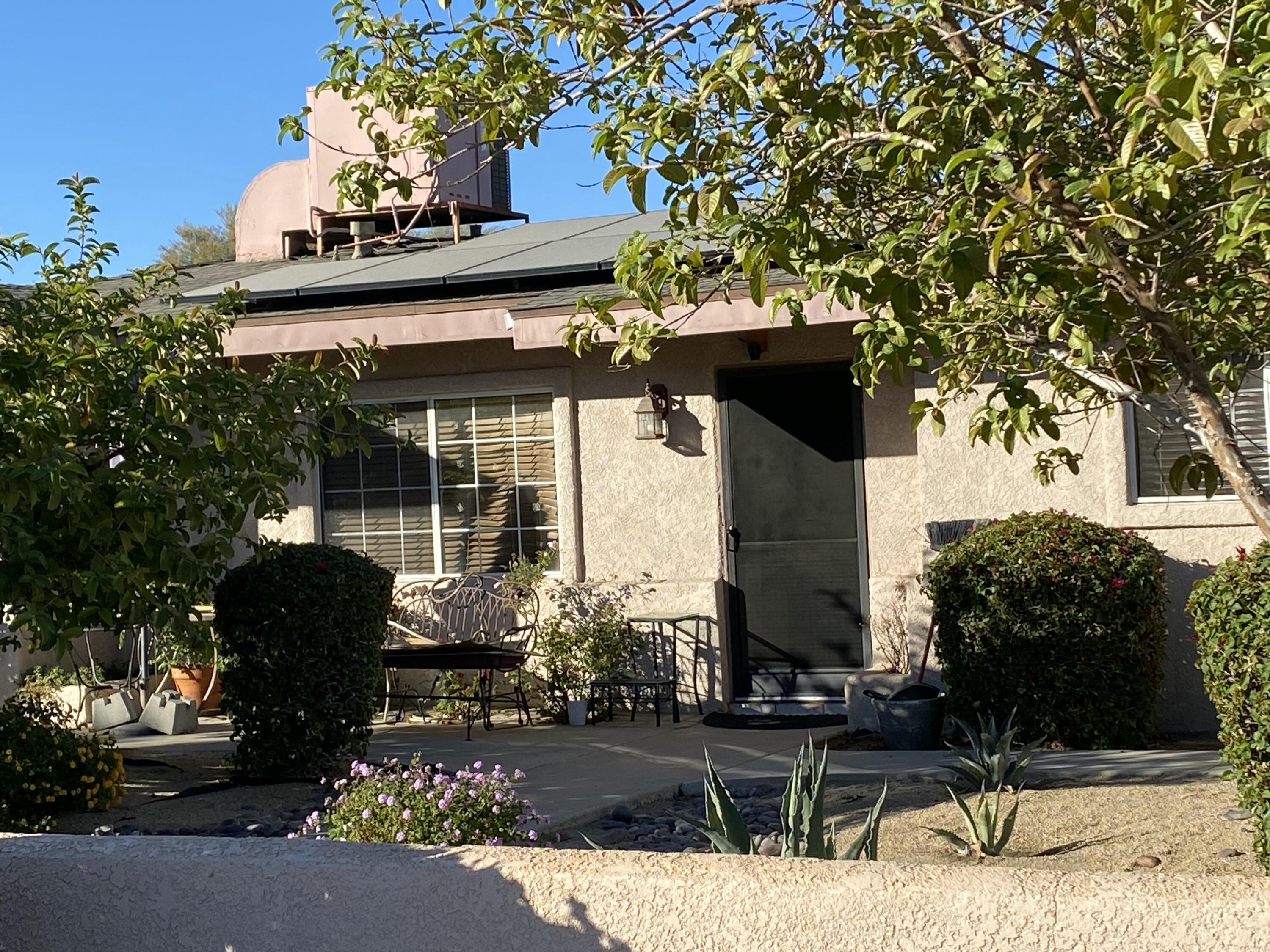 a front view of a house with a tree