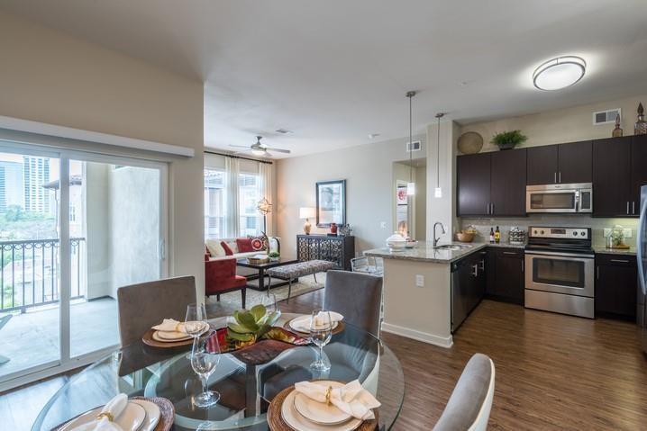 a living room with furniture kitchen view and a large window