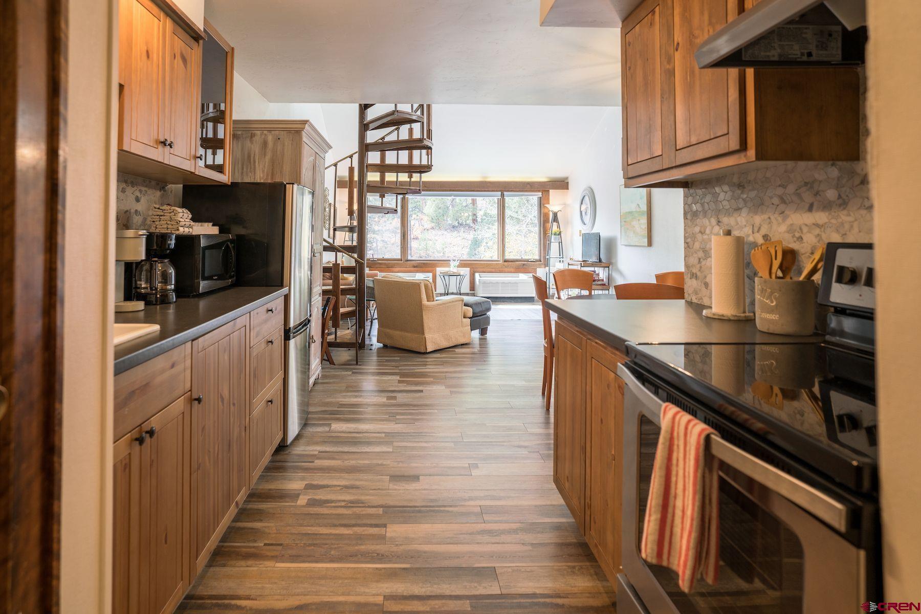 a kitchen with stainless steel appliances a sink dishwasher stove refrigerator and cabinets