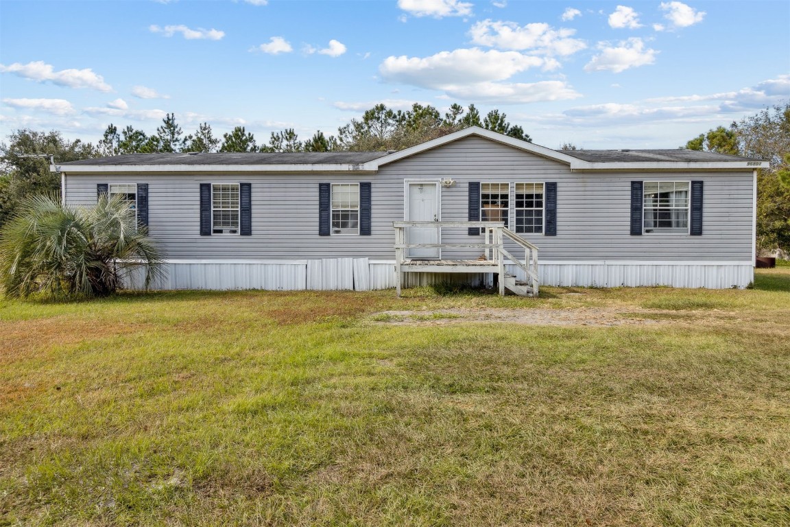 a view of house with a yard