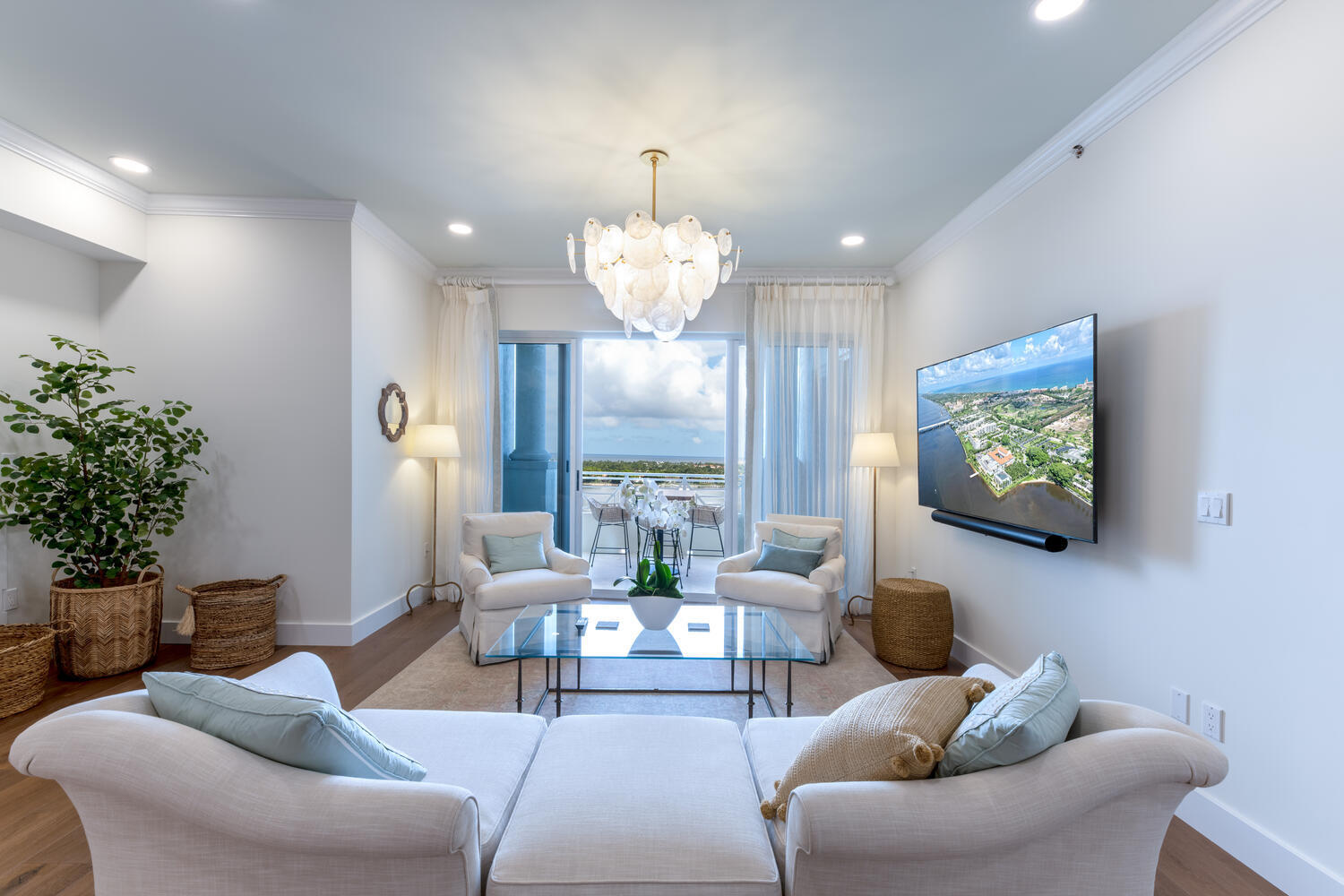 a living room with furniture a chandelier and a flat screen tv