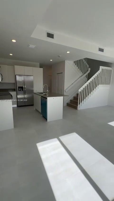 a kitchen with a refrigerator and white cabinets