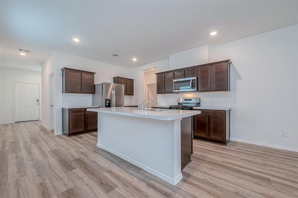 a kitchen with stainless steel appliances a refrigerator sink and microwave