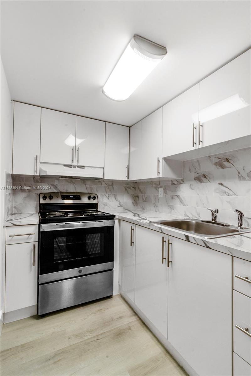 a kitchen with granite countertop a stove and a sink