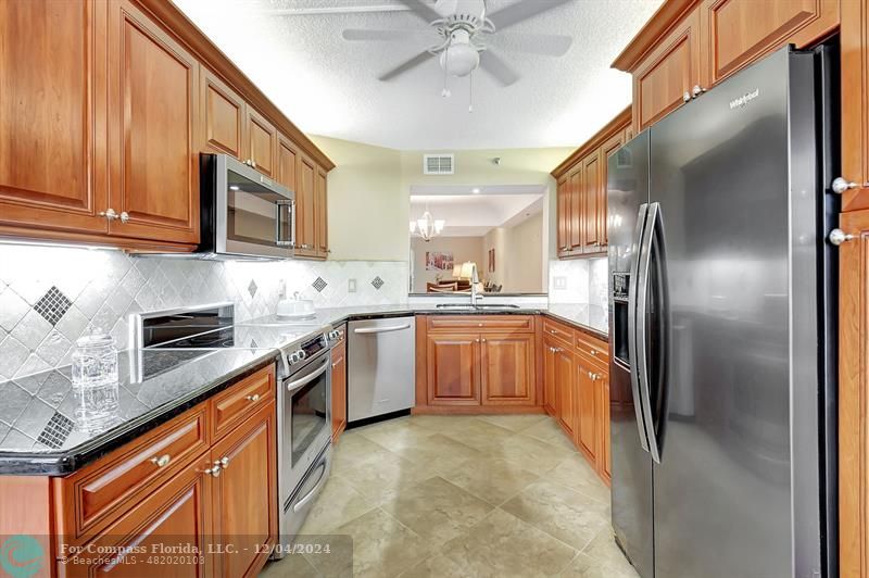 a kitchen with stainless steel appliances granite countertop a refrigerator sink and cabinets